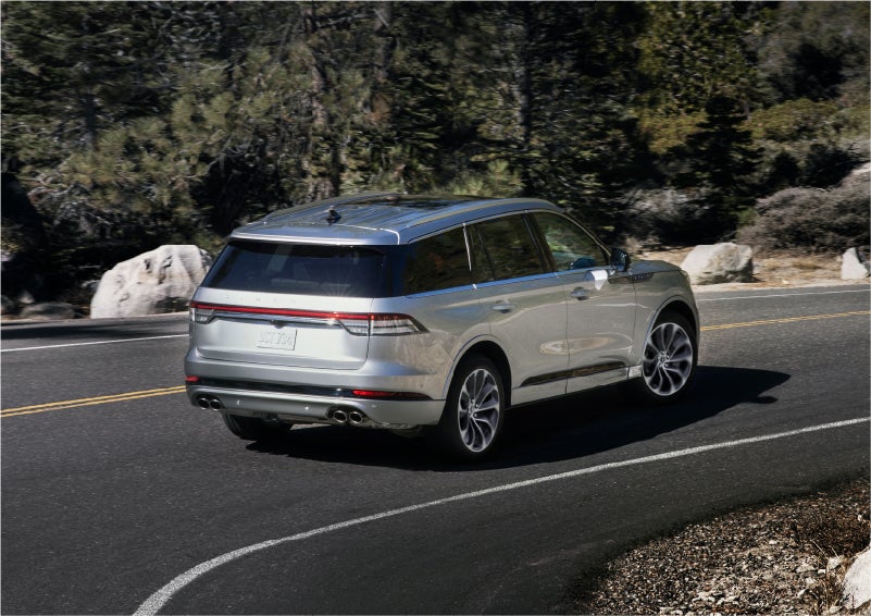 A 2023 Lincoln Aviator® Grand Touring model is shown being driven on a tight turn of a mountain road | Astro Lincoln in Pensacola FL