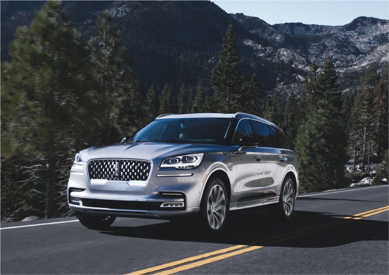 A 2023 Lincoln Aviator® Grand Touring SUV being driven on a winding road to demonstrate the capabilities of all-wheel drive | Astro Lincoln in Pensacola FL